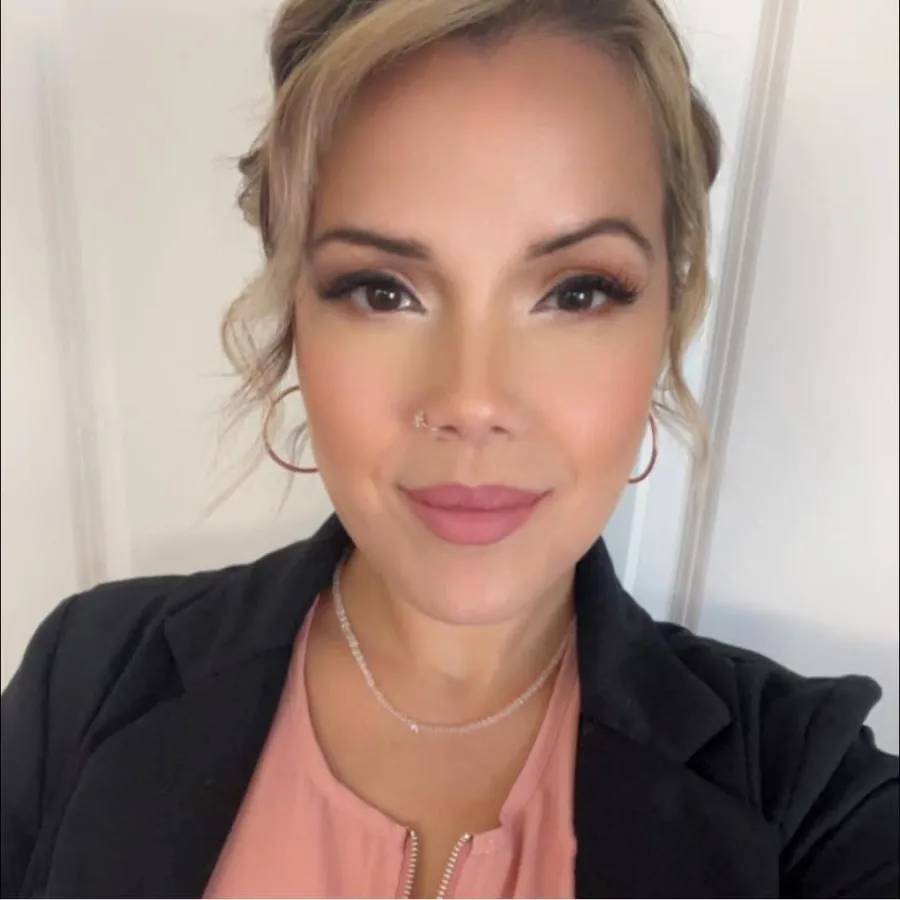 Sheila Cardoso smiling, wearing a black blazer and pink top